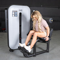 Thumbnail for Woman using a gray and black ab/back combo machine for abdominal workouts.