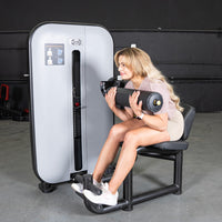 Thumbnail for Woman using a gray and black Vogue AB/Back Combo fitness machine for abdominal and back workouts.