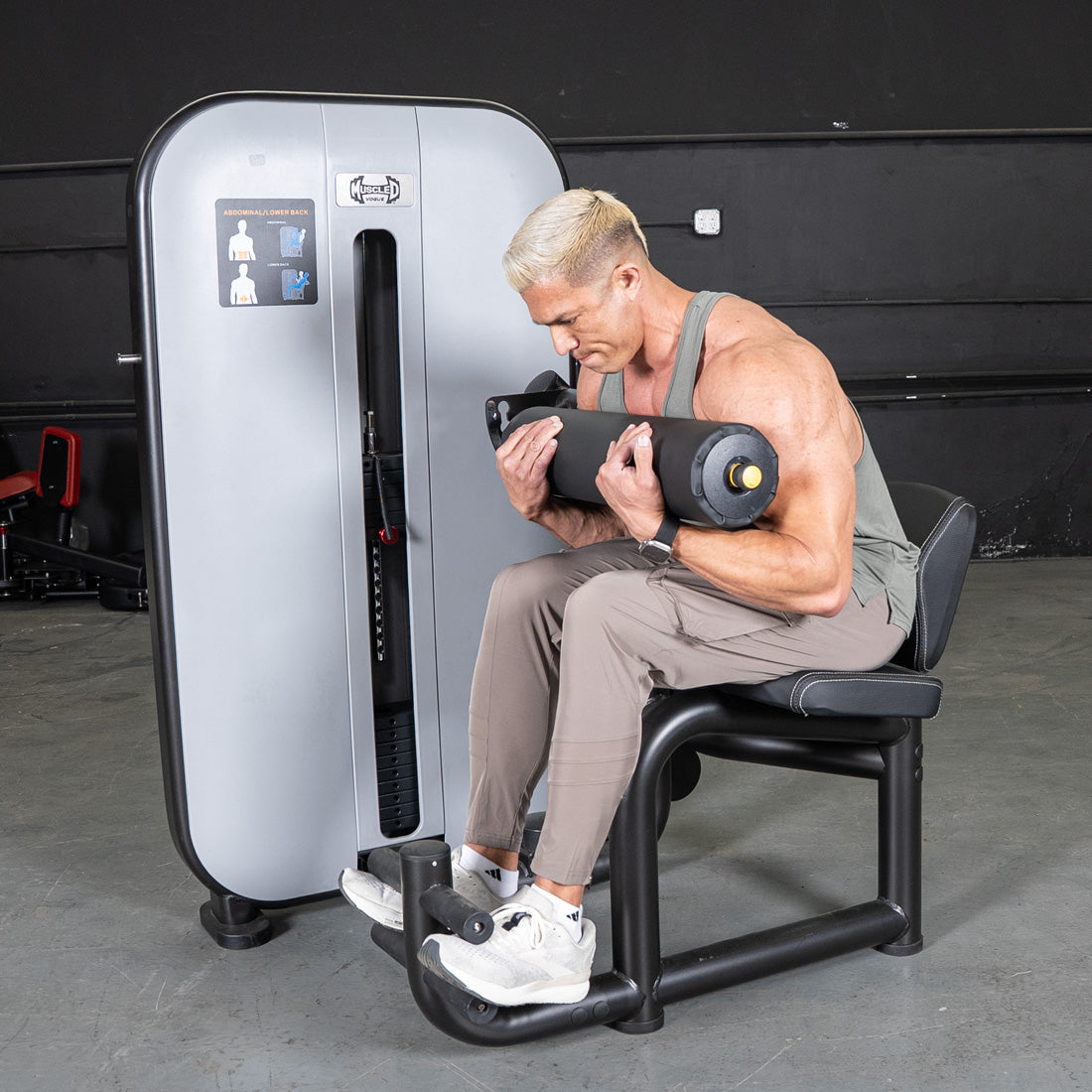 Man using a gray and black ab/back combo machine for abdominal workouts.