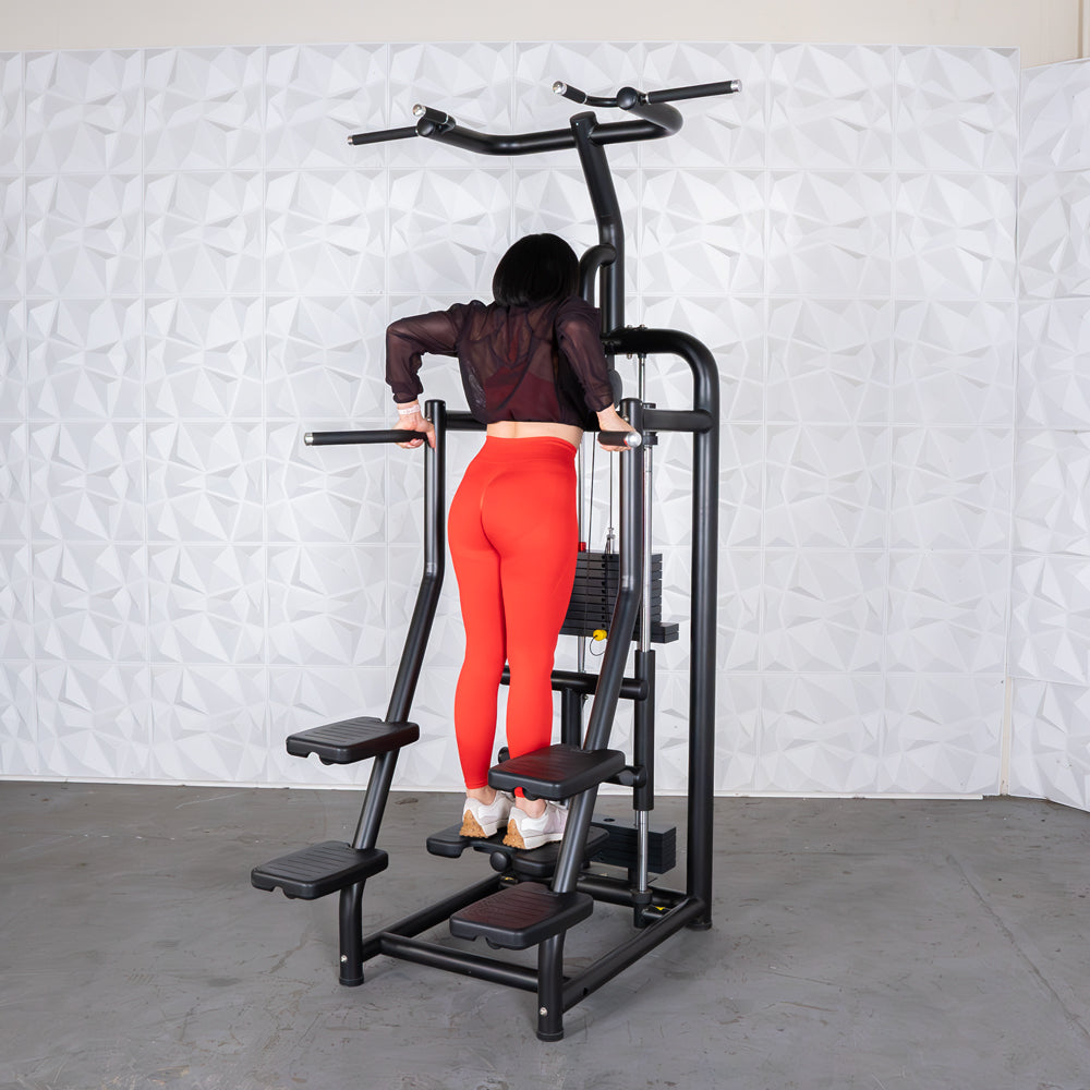 Woman in red leggings using a black assisted chin/dip machine with a weight stack.