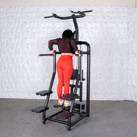 Thumbnail for Woman in red leggings using a black assisted chin/dip machine with a weight stack.