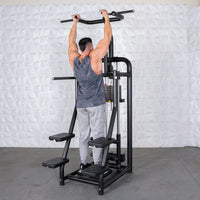 Thumbnail for Man using a black assisted chin/dip machine with multiple grip options and weight stack.