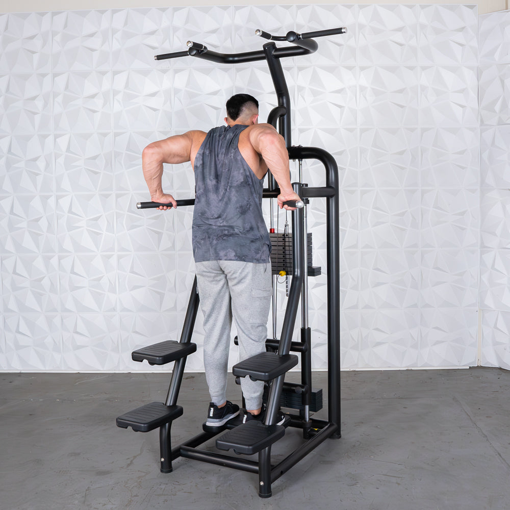 Man doing dips on a black assisted chin/dip machine with weight stack.