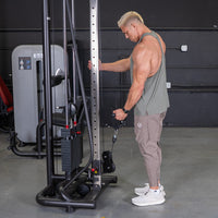 Thumbnail for Muscular man using a cable crossover machine for a triceps workout in a gym.