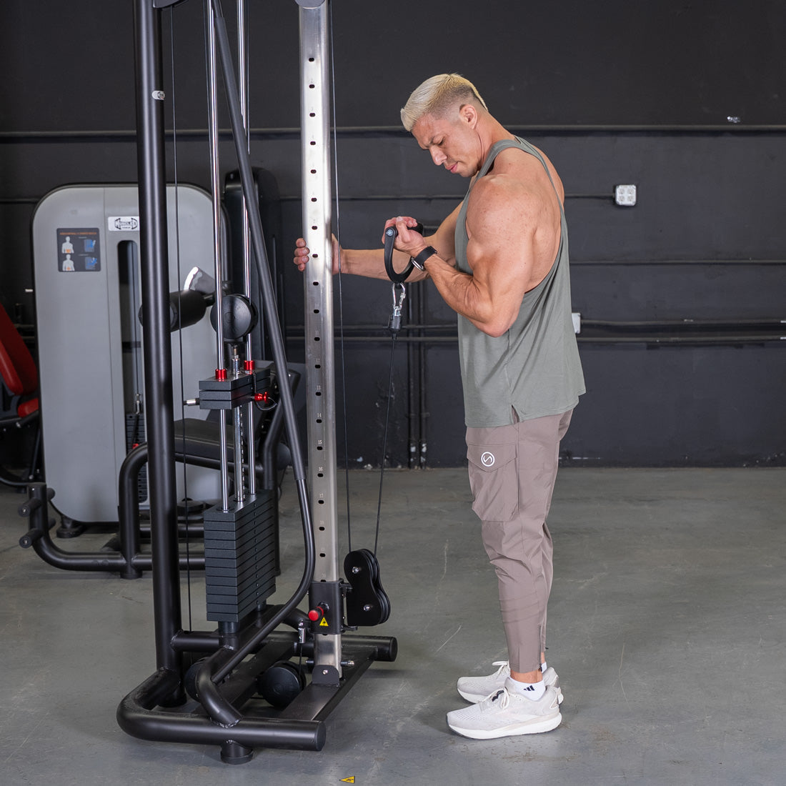 Man doing bicep curls on a black cable crossover machine with pin selectorized weights.