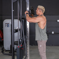 Thumbnail for Man adjusting the pulley height on a cable crossover machine in a gym.