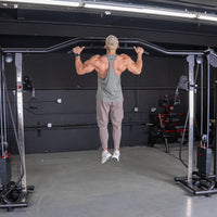 Thumbnail for Man doing a pull-up on a cable crossover machine in a gym.
