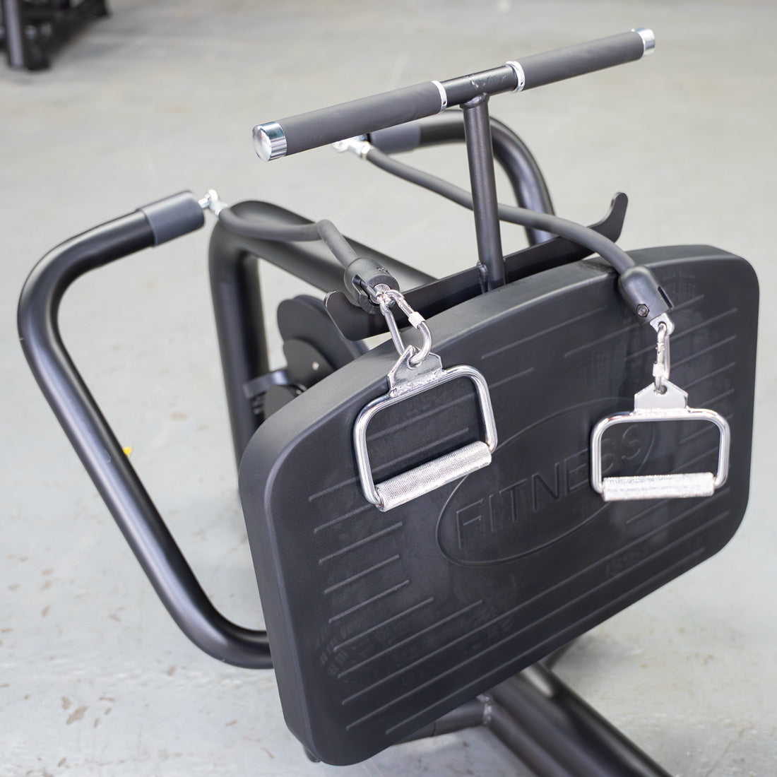 Close-up of a black seated low row machine with two silver D-handles attached to cables.