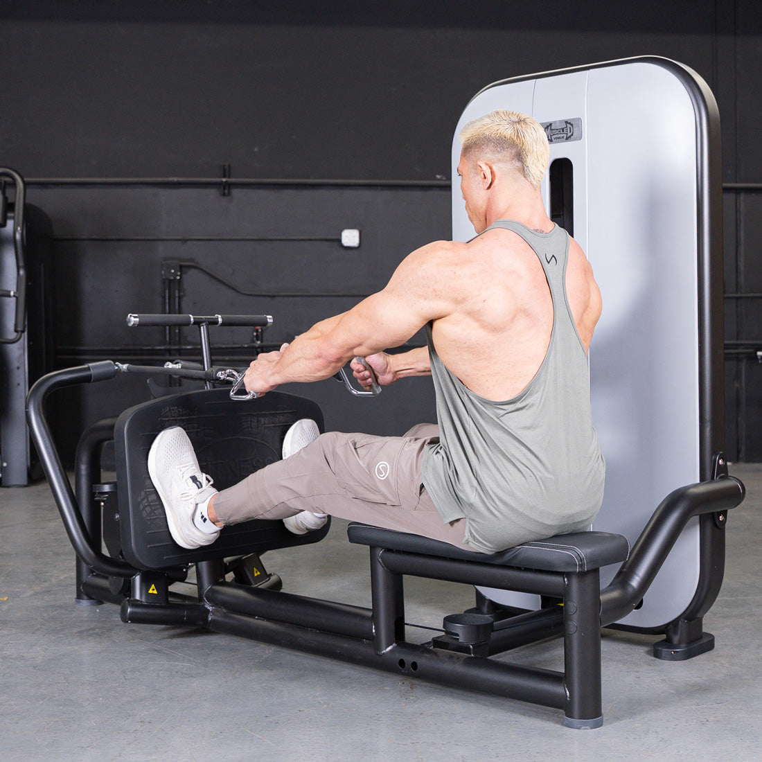 Man performing a seated low row exercise on a gym machine.
