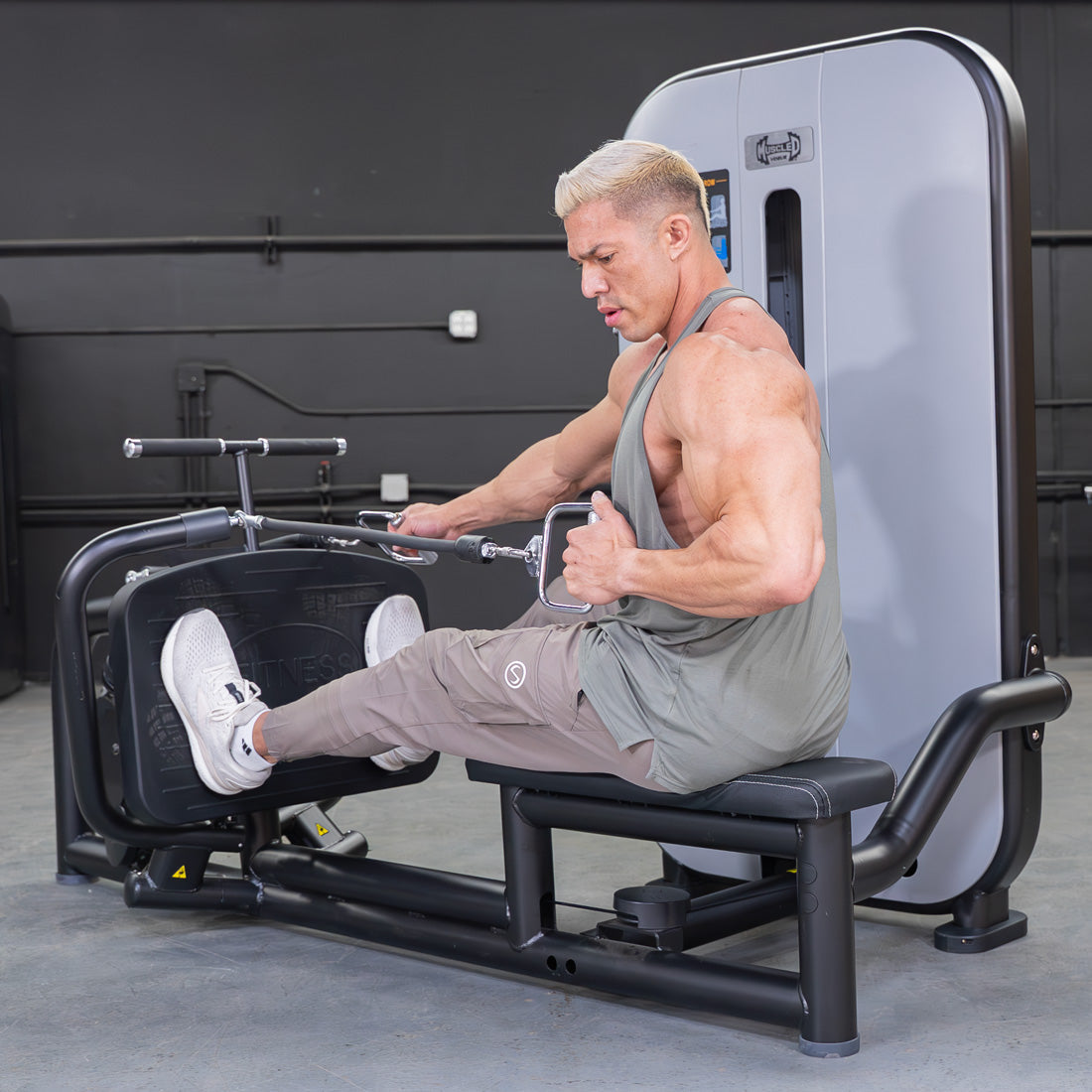 Man using a seated low row machine, pulling handles towards his torso.