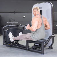 Thumbnail for Man using a seated low row machine, pulling handles towards his torso.