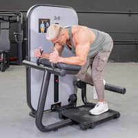 Thumbnail for Man using a gray and black glute extension machine in a gym.