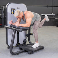 Thumbnail for Man performing glute extension on a gray and black fitness machine.