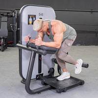 Thumbnail for Man using a glute extension machine, with one leg extended back, in a gym setting.