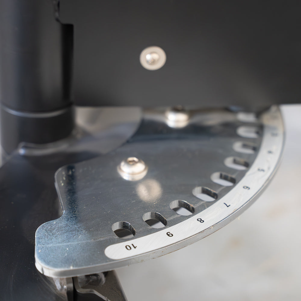 Close-up of the adjustable seat's pin selectorized mechanism with numbered holes on a metal plate.