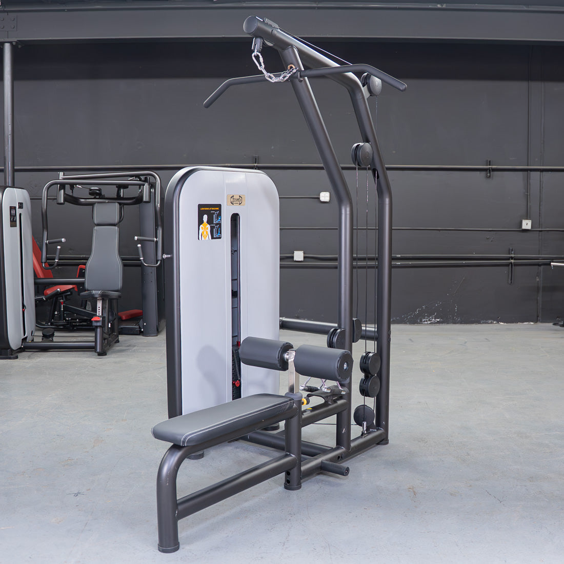 Black and gray lat/low row machine with an adjustable seat and pin selectorized weights in a gym.