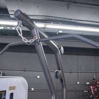 Thumbnail for Close-up of a lat pulldown bar attached to a gray fitness machine with a chain and carabiner.