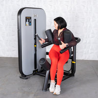 Thumbnail for Woman in red leggings using a gray and black rotary torso machine.