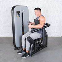 Thumbnail for Man using a gray and black rotary torso machine with an adjustable seat and pin selectorized weights.
