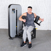 Thumbnail for Man using a rotary torso machine, engaging his core with padded armrests and handles.