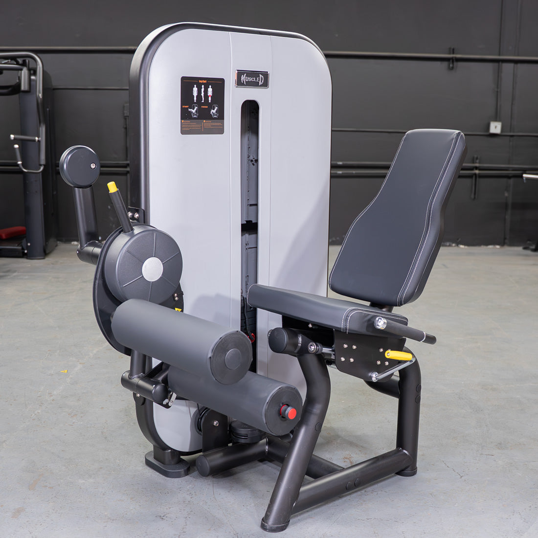 Gray and black seated leg curl machine with adjustable seat and pin selectorized weight stack.