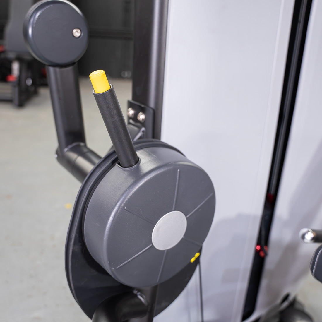 Close-up of a leg curl machine's adjustment pin and weight stack.