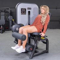 Thumbnail for Woman seated on a leg curl machine, performing a hamstring workout.