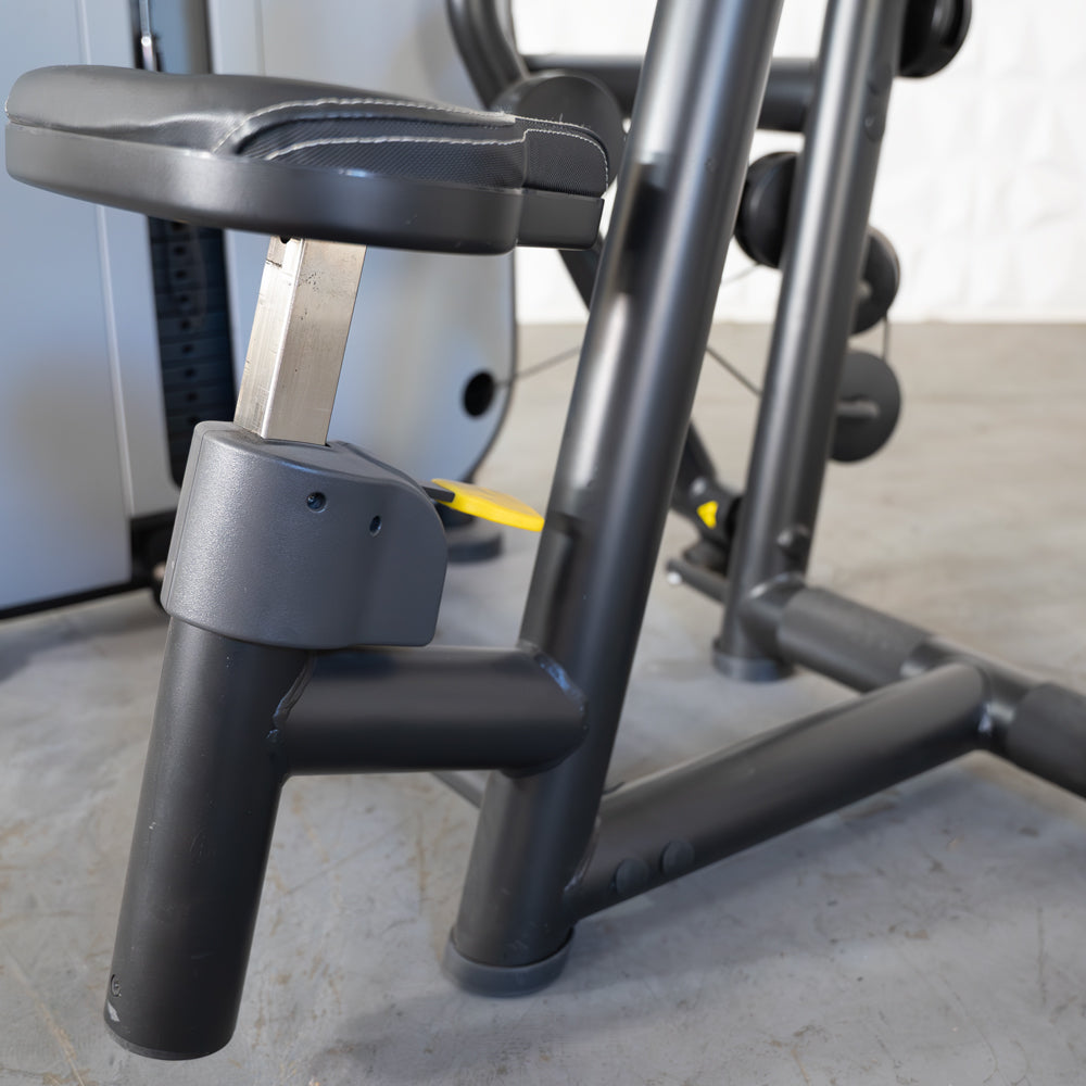 Close-up of a black seated row machine's adjustable seat and frame, with a yellow adjustment pin visible.