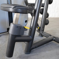 Thumbnail for Close-up of a black seated row machine's adjustable seat and frame, with a yellow adjustment pin visible.