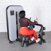 Thumbnail for Woman in red leggings using a grey and black seated row machine.