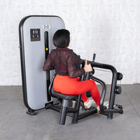 Thumbnail for Woman in red leggings using a gray and black seated row machine.