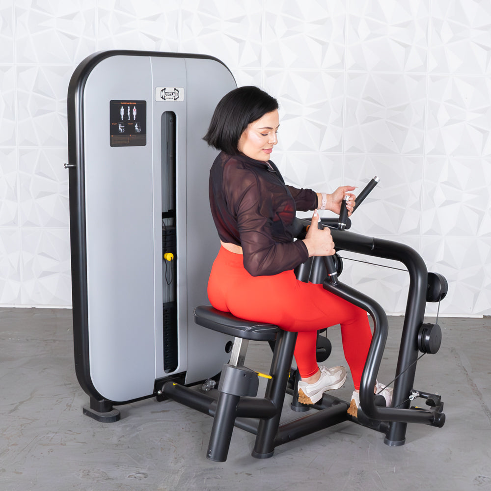 Woman in red leggings using a gray and black seated row machine.