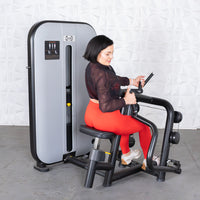 Thumbnail for Woman in red leggings using a gray and black seated row machine.