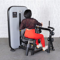 Thumbnail for Woman in red leggings using a gray and black seated row machine.