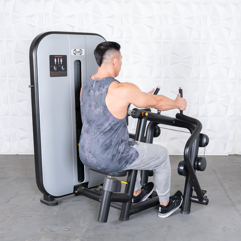 Man using a seated row machine, pulling handles towards his body.