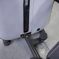 Thumbnail for Close-up of a weight stack with a red pin selector on a grey fitness machine.