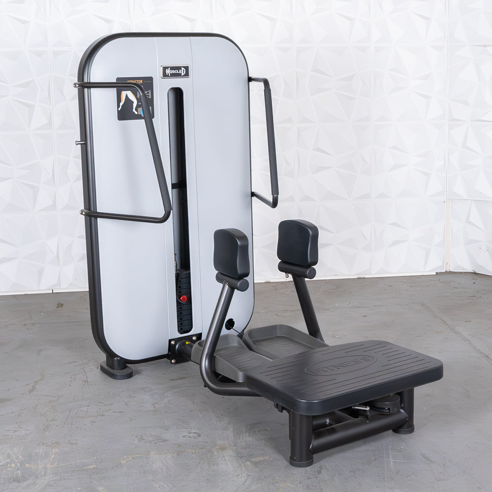 Gray and black standing abductor machine with a weight stack and foot platform.