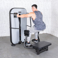 Thumbnail for Man using a standing abductor machine, pushing out with his left leg, in a gym setting.