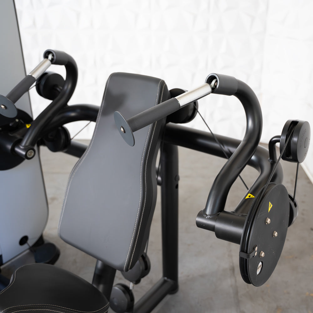 Close-up of a black triceps extension machine with padded backrest and handles.