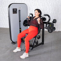 Thumbnail for Woman in red leggings using a gray and black triceps extension machine.