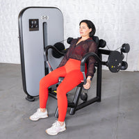 Thumbnail for Woman in red leggings using a black and gray triceps extension machine.