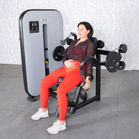 Thumbnail for Woman in red leggings using a triceps extension machine with an adjustable seat.