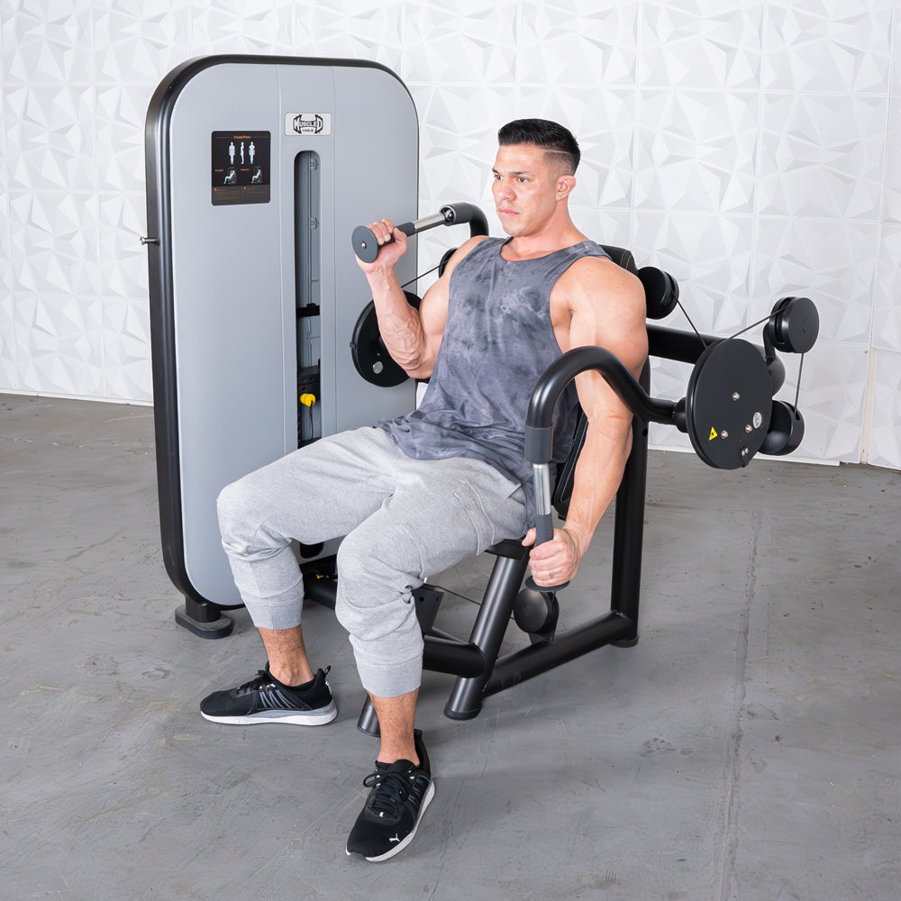 Man using a gray and black triceps extension machine with an adjustable seat.