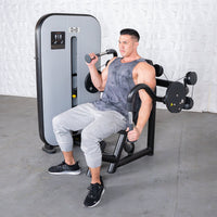 Thumbnail for Man using a gray and black triceps extension machine with an adjustable seat.