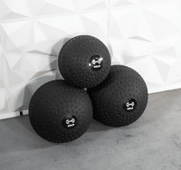 Thumbnail for Three black slam balls with textured surfaces and weight labels (20LB, 30LB, 50LB) stacked on a concrete floor.