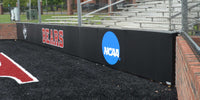 Thumbnail for Black folding backstop pads printed with Bears and an NCAA logo along a brick wall