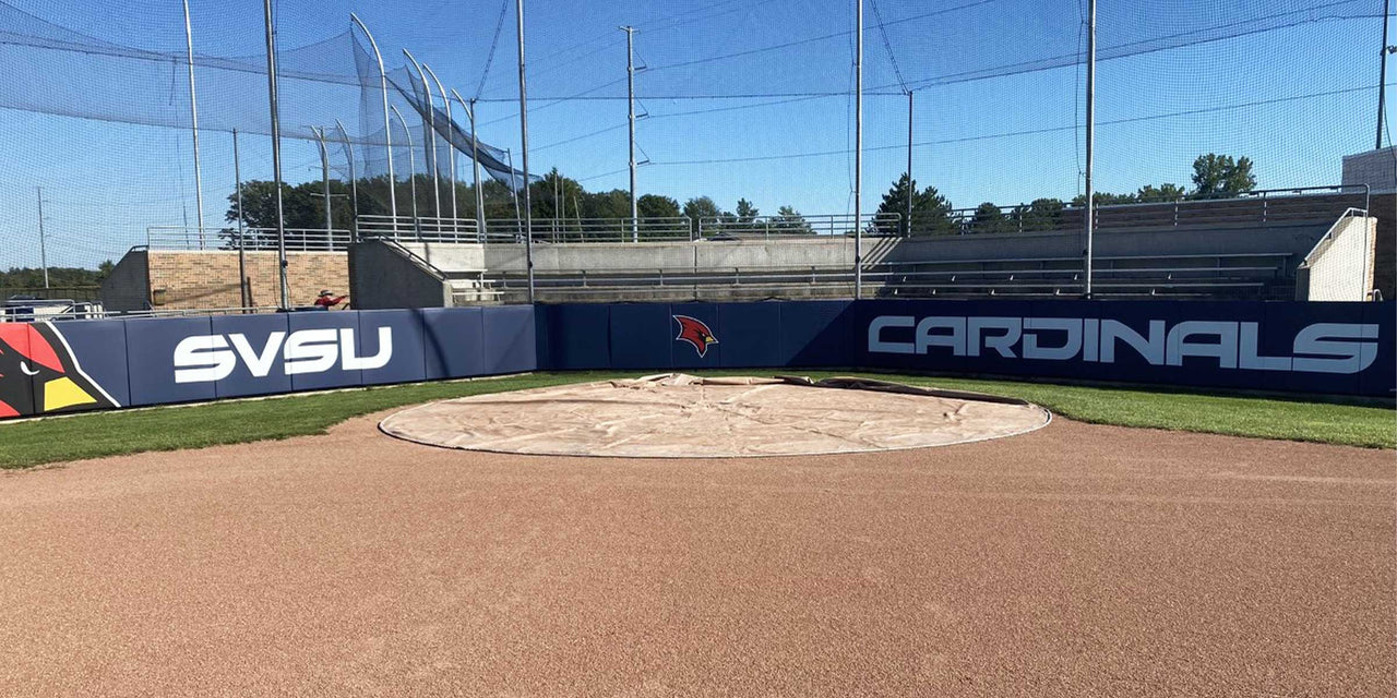 Navy backstop padding printed with SVSU Cardinals behind a softball circle