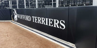 Thumbnail for Black backstop padding printed with Wofford Terriers in large white letters