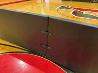 Thumbnail for Close-up of gym barrier pad velcro straps and D-ring attachment system on basketball court, showing modular connection hardware that links divider pads together for secure free-standing gym partitions