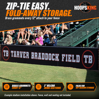 Thumbnail for Black stadium wall padding printed with Tarver Braddock Field lettering and TB logos below fans in the bleachers